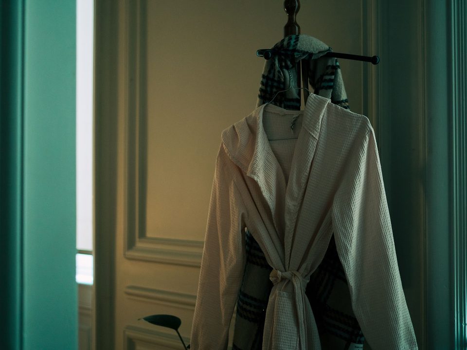 Neutral bathrobe hanging neatly in a softly lit room