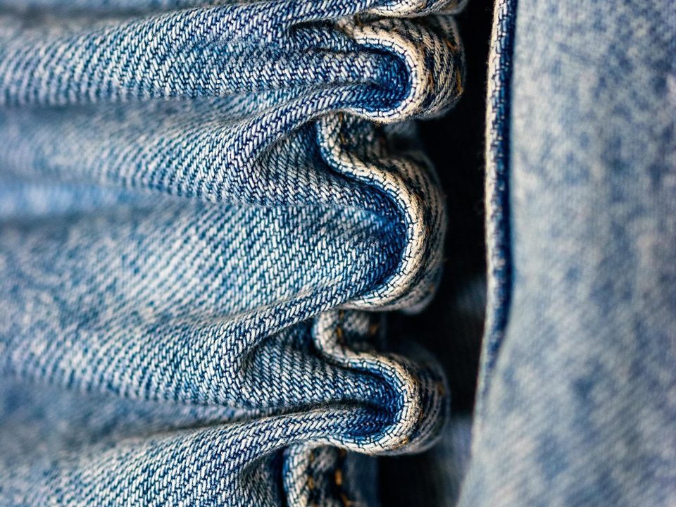 Close-up of folded blue denim fabric and visible twill texture