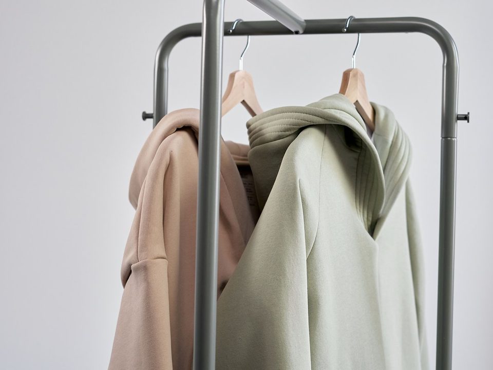 Neutral-coloured hoodies hanging on a garment rail